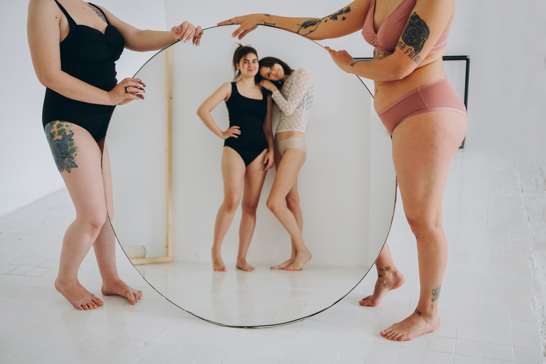 Young women with different body types in a studio with a mirror